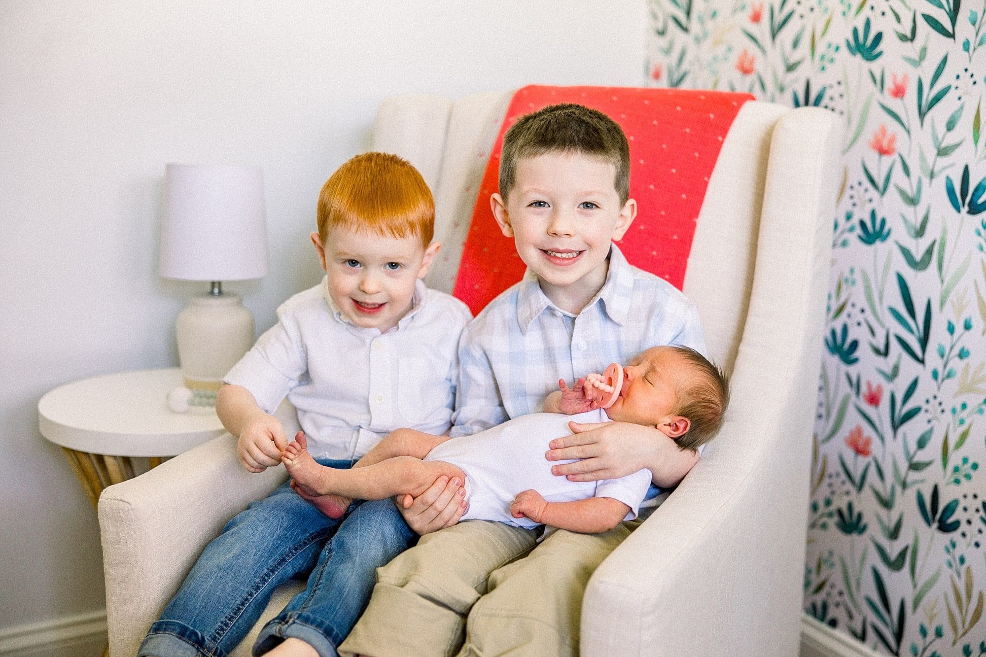 Proud big brothers holding new baby sister in Miami area home