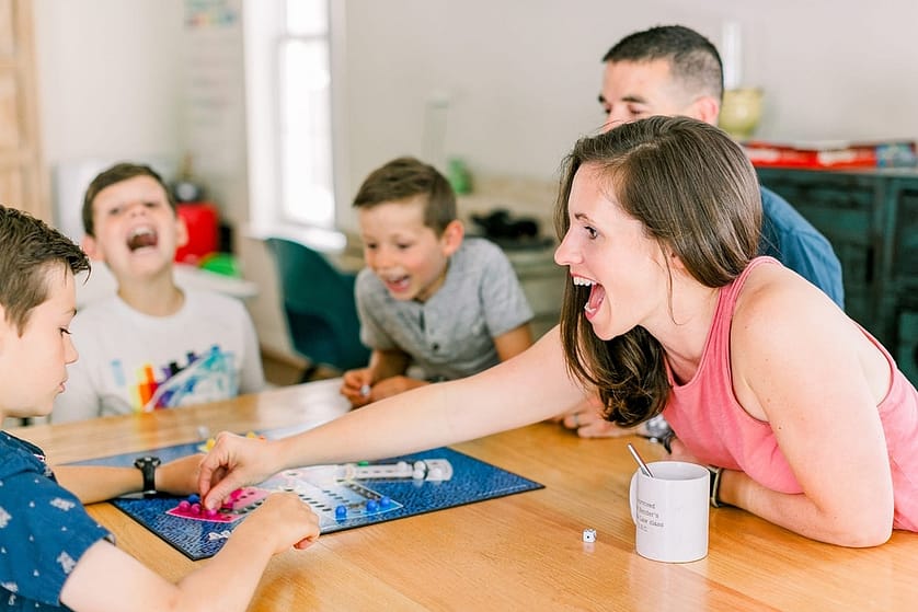 Excited Miami mom playing board games with family